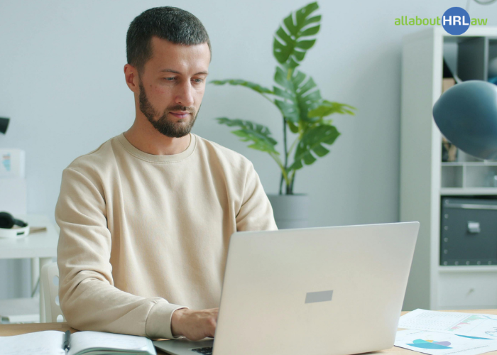 Ein Mitarbeiter arbeitet konzentriert am Laptop und zeigt, wie sich Unterbrechungen im Arbeitsalltag und ungestörte Arbeitsphasen in Einklang bringen lassen.