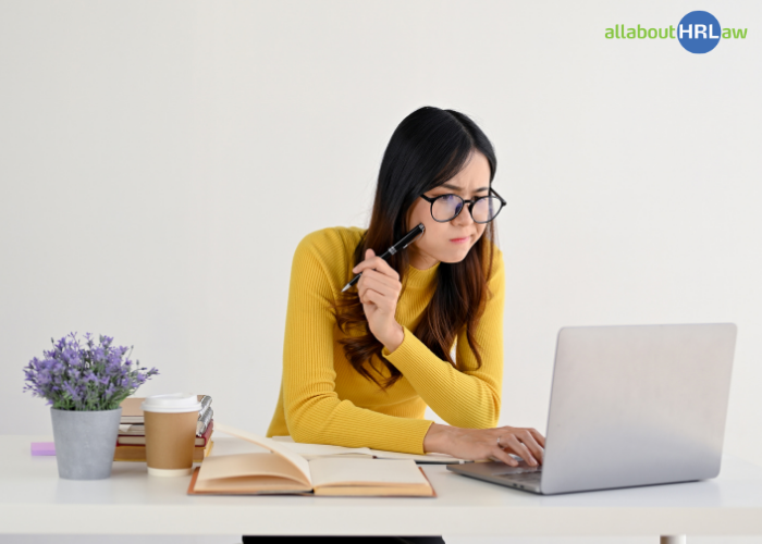 An employee looking at a chat message on a laptop – a typical situation in which misunderstandings at work can arise from unclear digital communication.